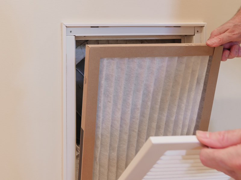 Homeowner changing their HVAC filter.