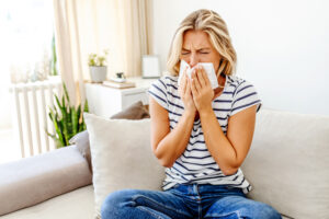 women sneezing due to pollen.