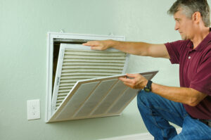 HVAC tech replacing air filter.