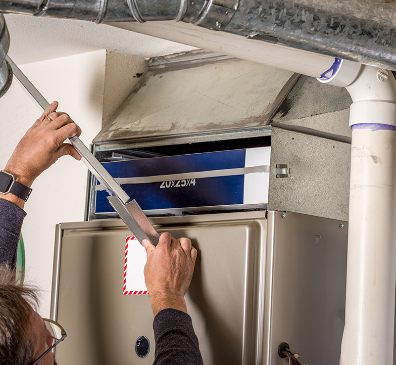 Technician removing furnace panel cover