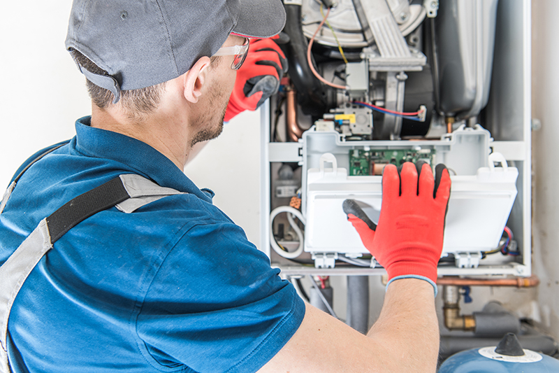 Technician inspecting home furnace.