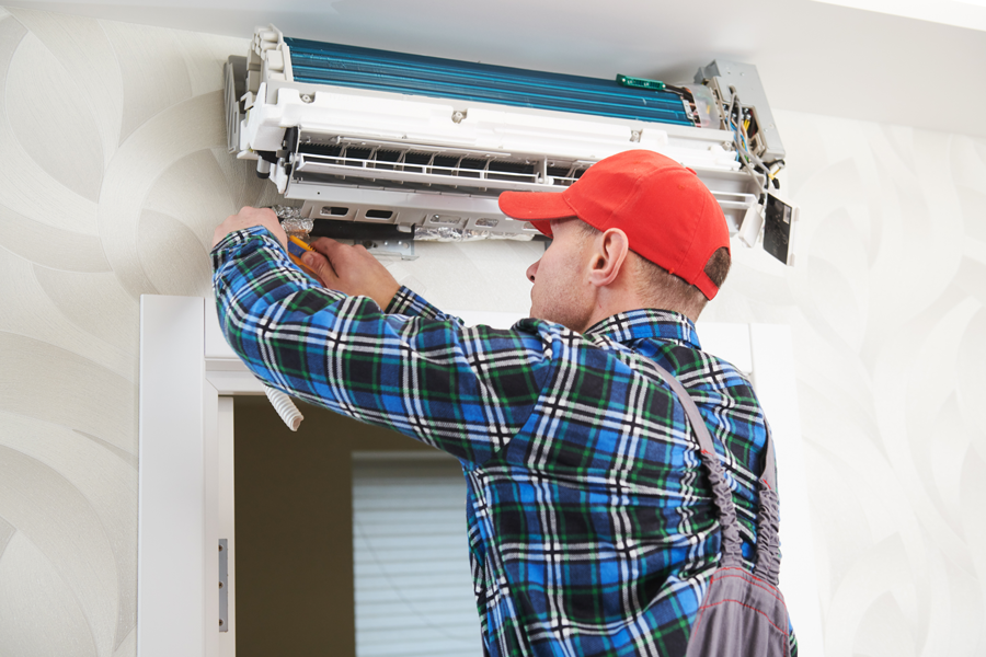 Thornton employees repairing wall AC unit
