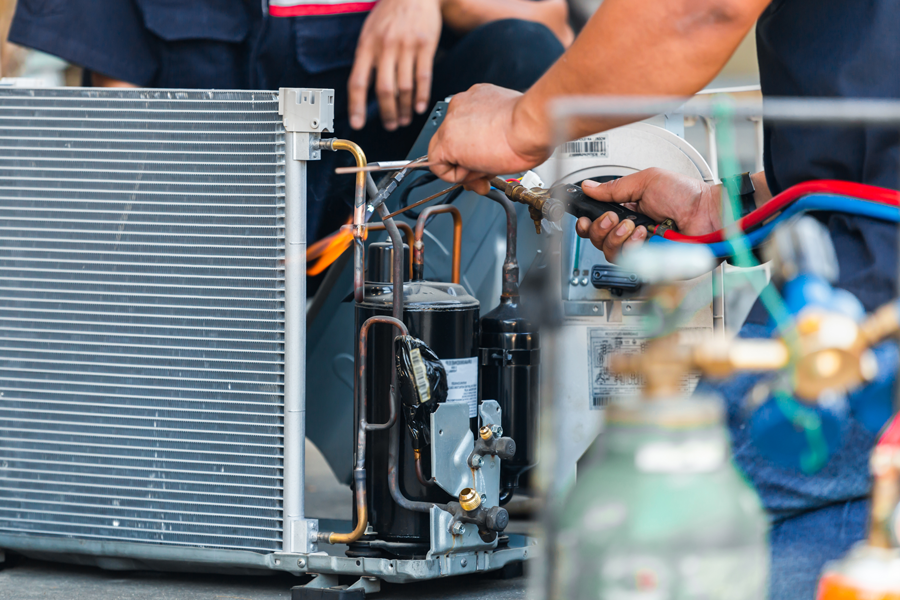 HVAC technicians fixing broken AC unit