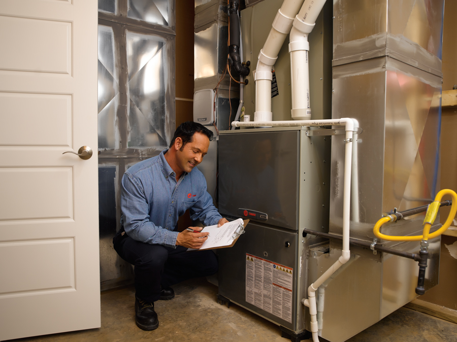 HVAC technician inspecting a furnace or central heating system