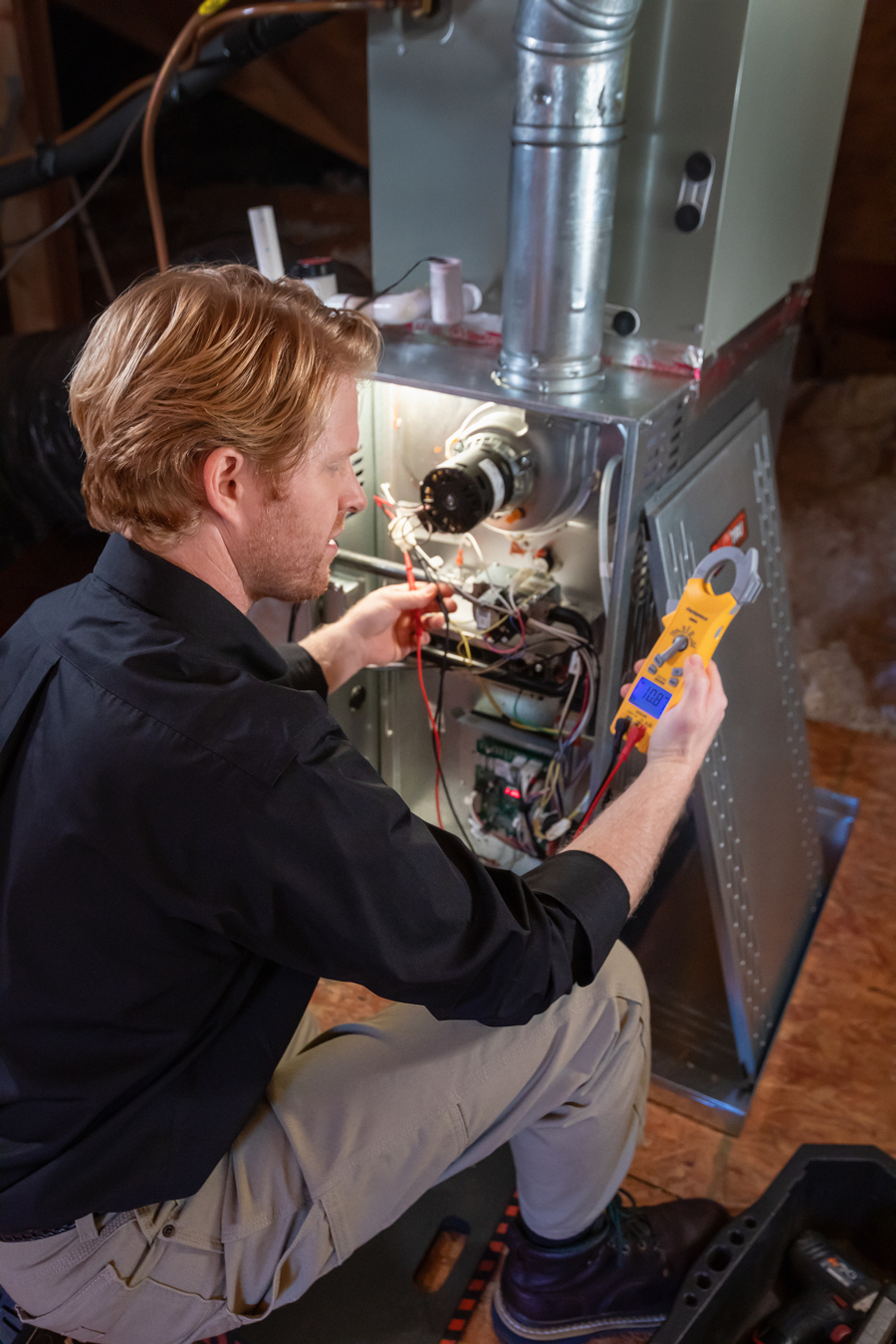 HVAC technician working on furnace.
